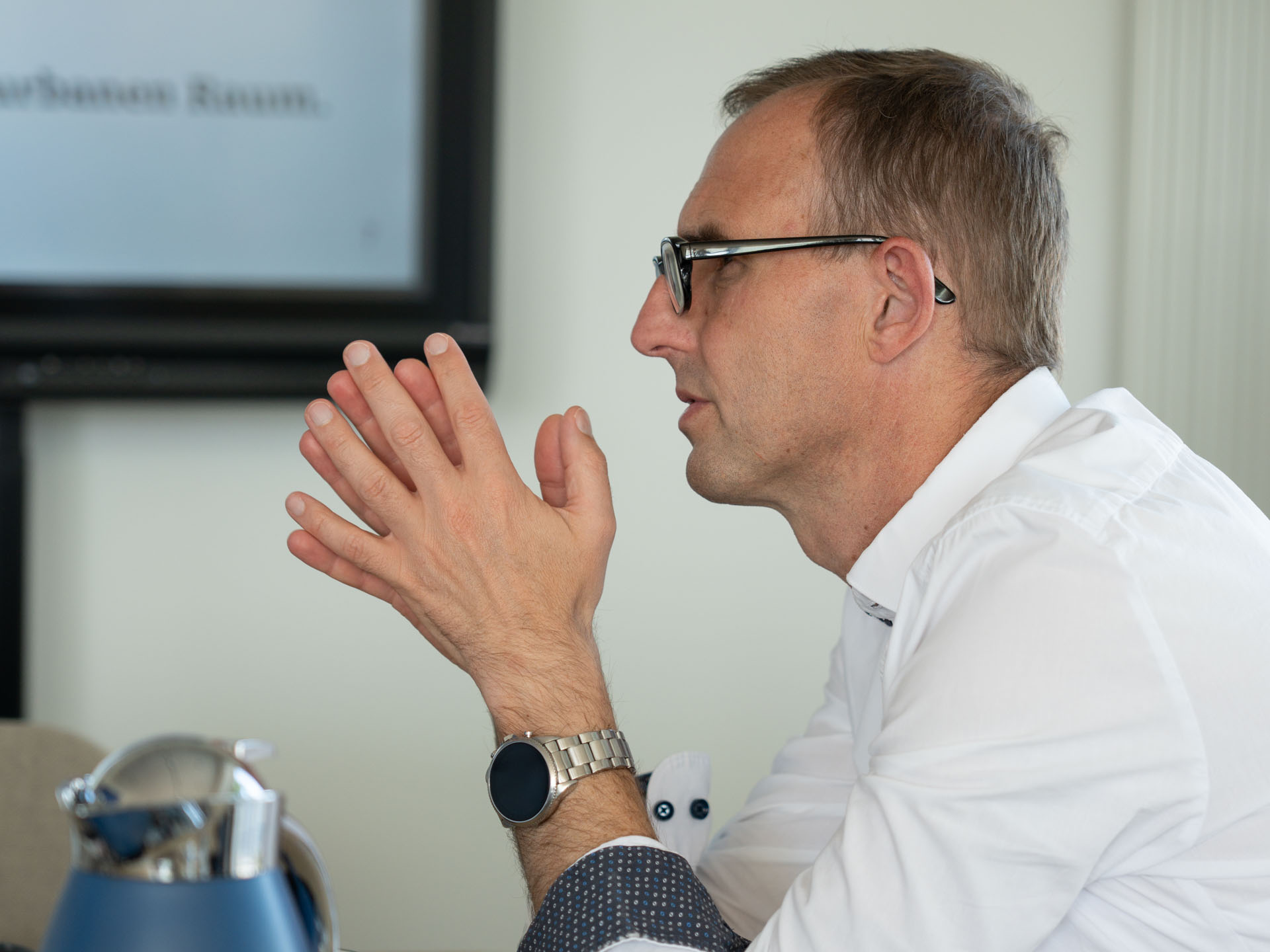 Ein Mann mit Brille wird von der SEite gezeigt. Es ist Digitalisierungsminister Dirk Schrödter. Er hat eine Häne flach aneinandergelegt.