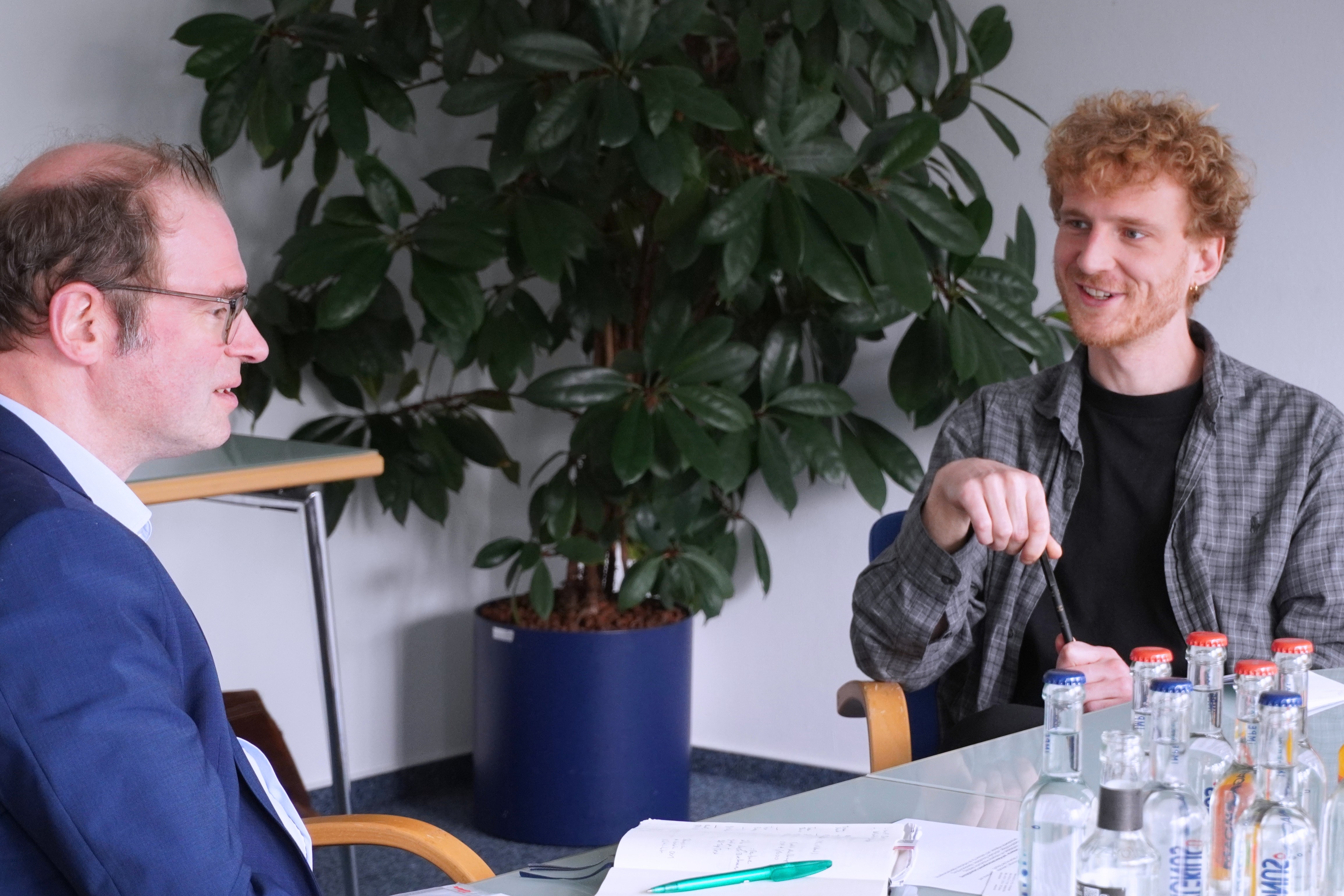Zwei Männer im Gespräch an einem Konferenztisch