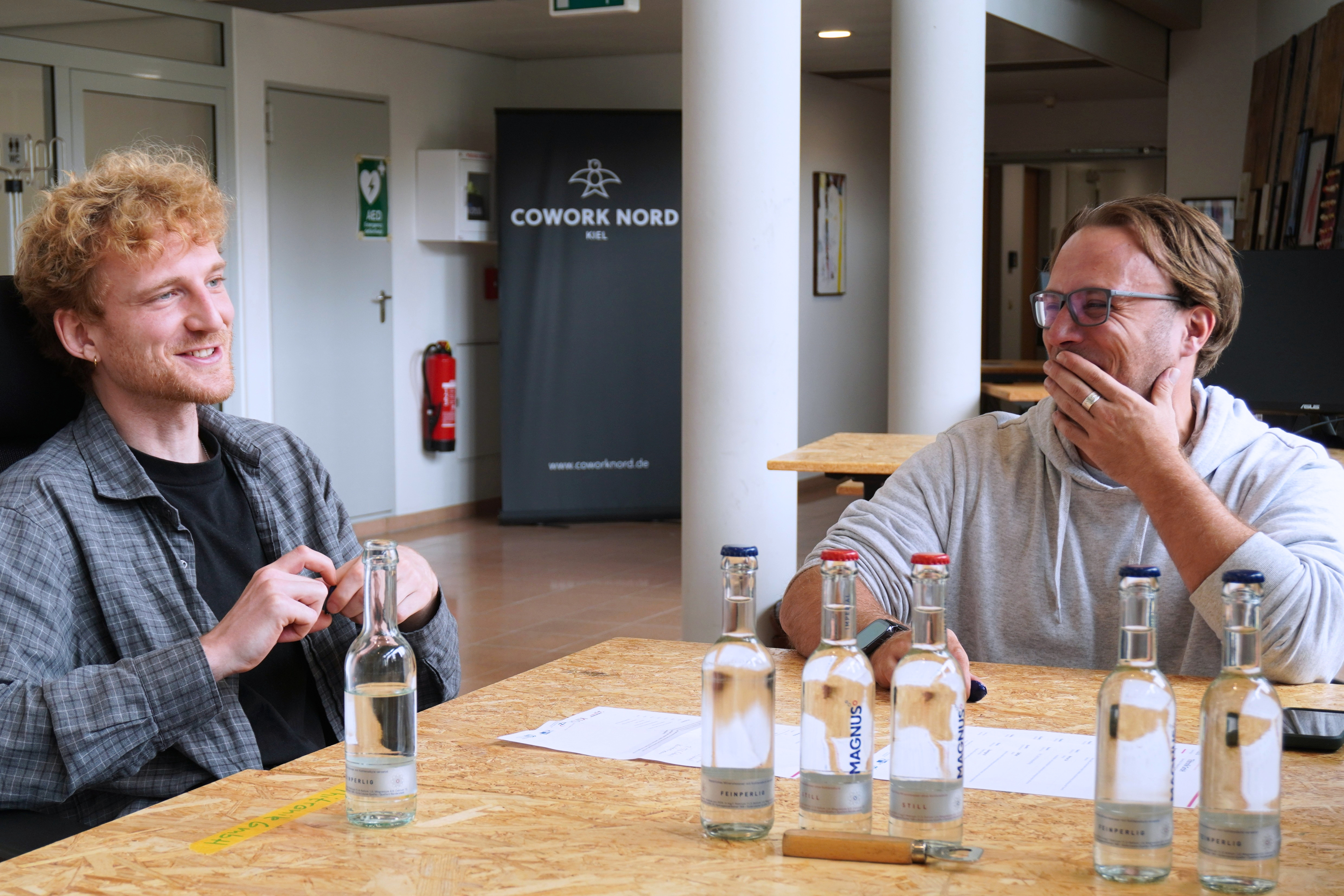 Zwei Männer lachen an einem Tisch