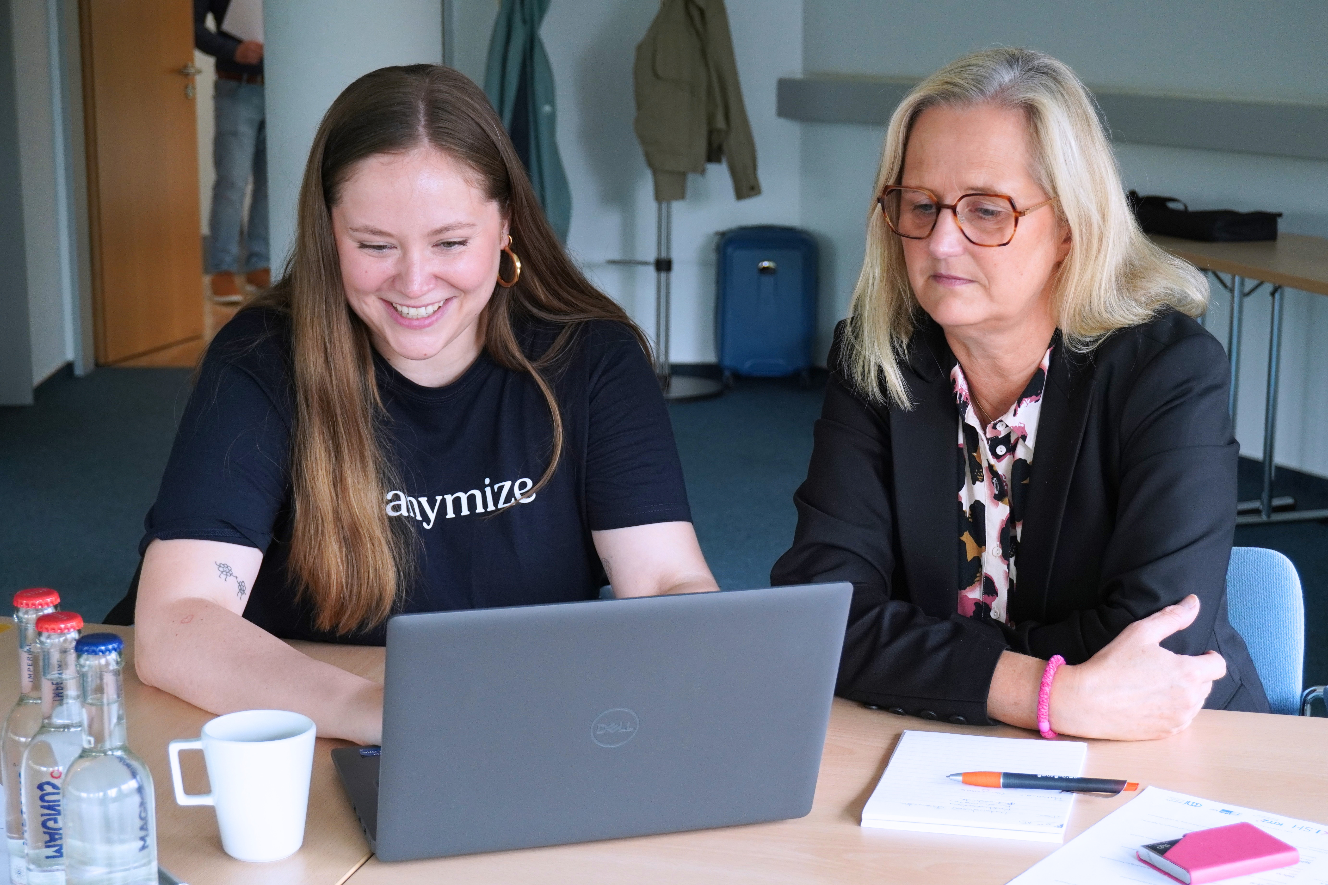 Zwei Frauen sitzen gemeinsam vor einem Laptop